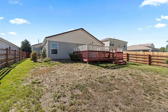 a view of a house with a yard and wooden fence