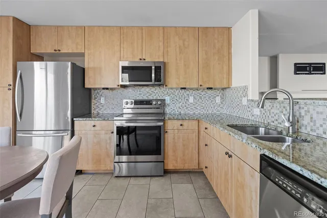 a kitchen with stainless steel appliances a sink cabinets and a refrigerator