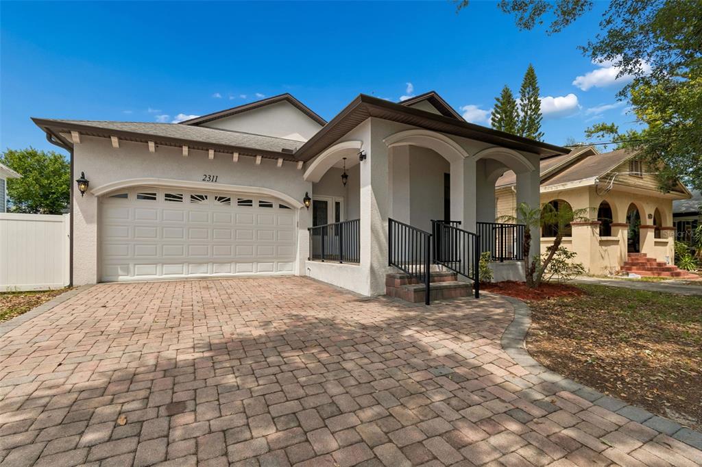 2311 West Aileen Street Tampa, FL 33607 - Photo 1 of 38 a view of a white house with a large windows and a yard