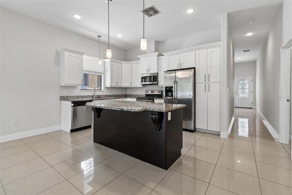 2311 West Aileen Street Tampa, FL 33607 - Photo 13 of 38 a kitchen with stainless steel appliances granite countertop a stove a sink a refrigerator and a cabinets