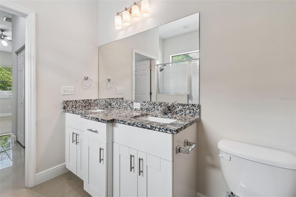 2311 West Aileen Street Tampa, FL 33607 - Photo 26 of 38 a bathroom with a granite countertop sink and a toilet