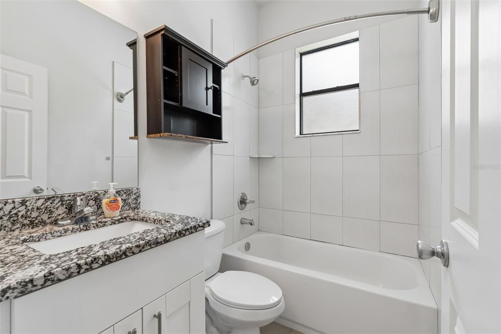 2311 West Aileen Street Tampa, FL 33607 - Photo 7 of 38 a bathroom with a granite countertop sink toilet and shower