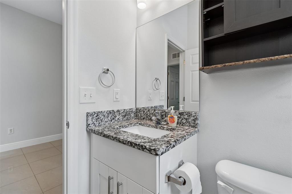2311 West Aileen Street Tampa, FL 33607 - Photo 8 of 38 a bathroom with a granite countertop sink and a mirror