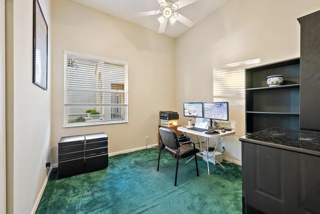 a view of a workspace with furniture and a window