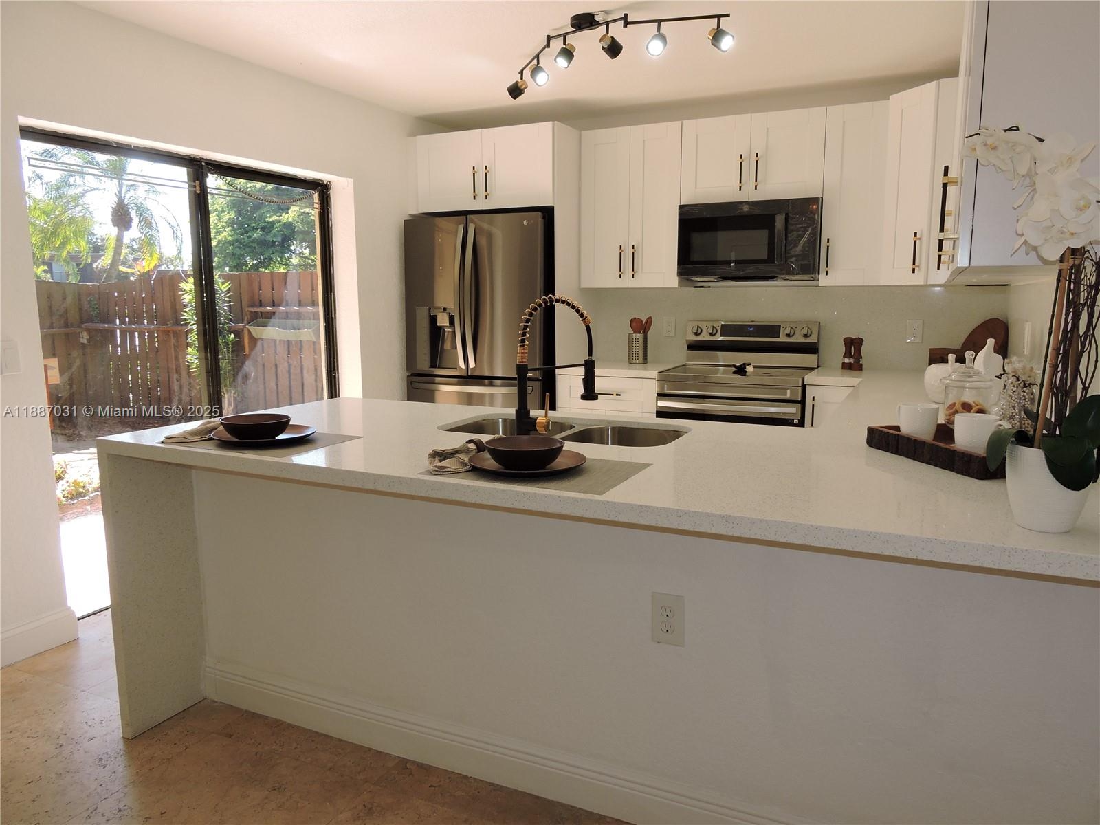 1316 Southwest 118th Terrace, Unit 1316 Davie, FL 33325 - Photo 12 of 44 a kitchen with a sink a stove and a refrigerator
