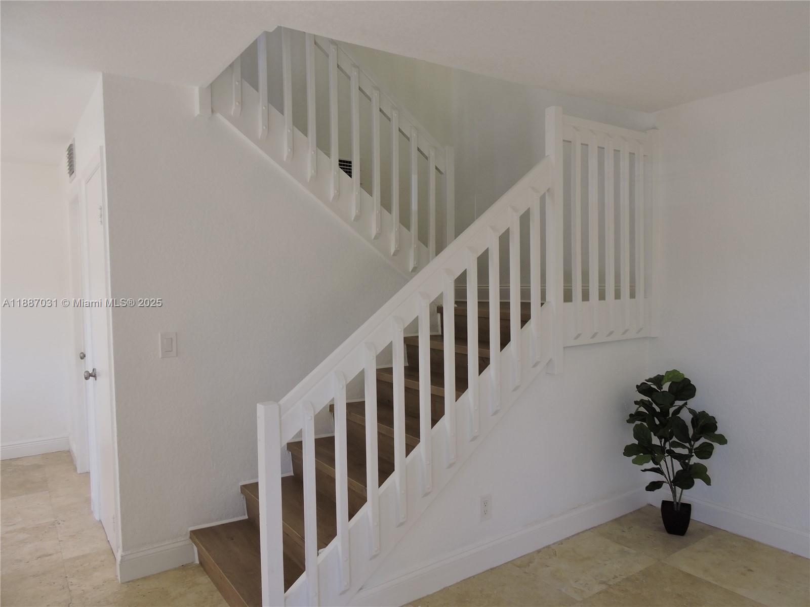 1316 Southwest 118th Terrace, Unit 1316 Davie, FL 33325 - Photo 18 of 44 a view of staircase with lots of frames on wall and stairs