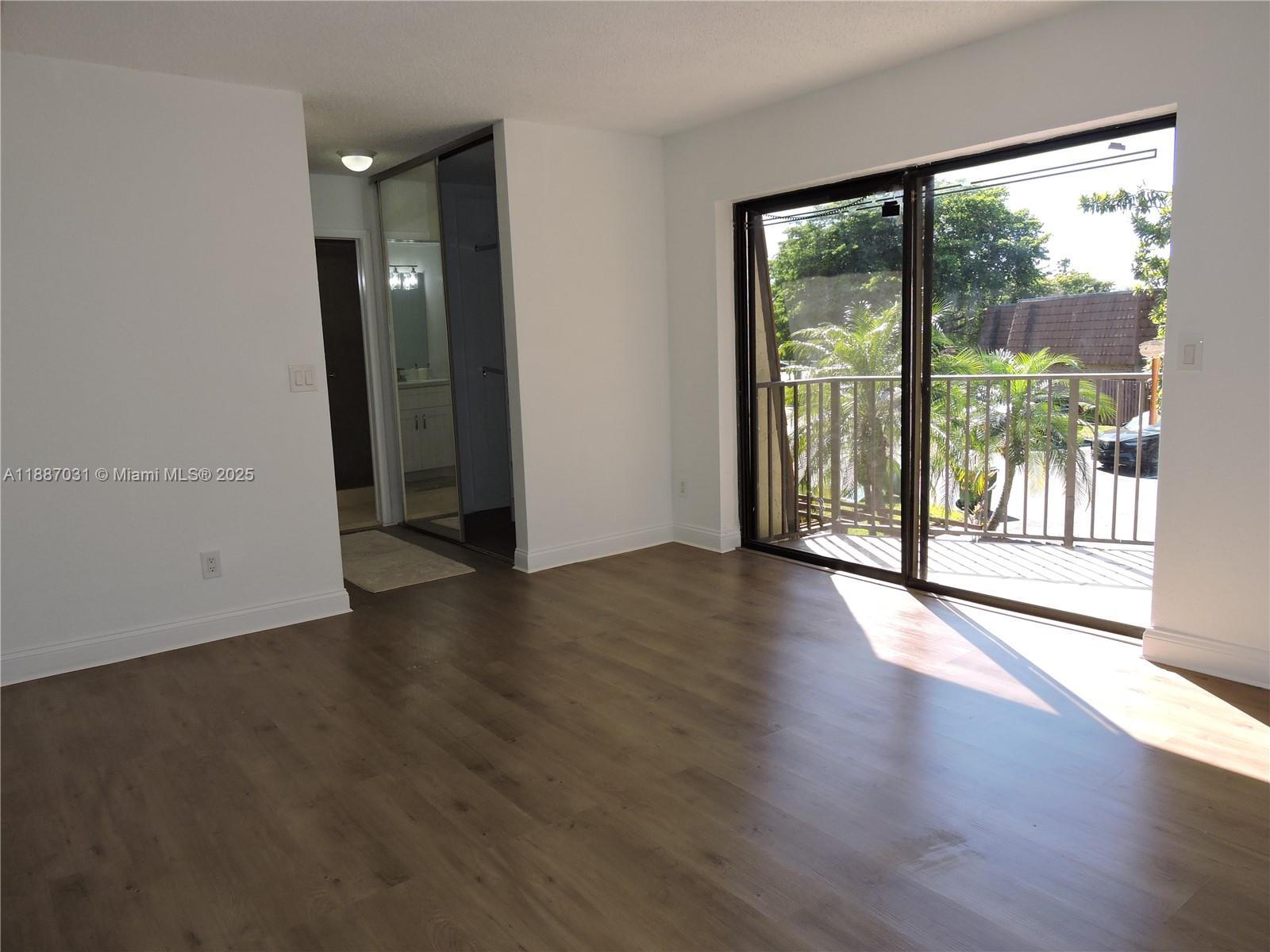 1316 Southwest 118th Terrace, Unit 1316 Davie, FL 33325 - Photo 24 of 44 an empty room with wooden floor and windows