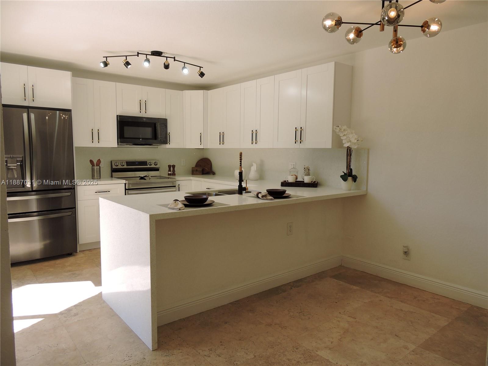 1316 Southwest 118th Terrace, Unit 1316 Davie, FL 33325 - Photo 8 of 44 a kitchen with a sink stainless steel appliances and white cabinets