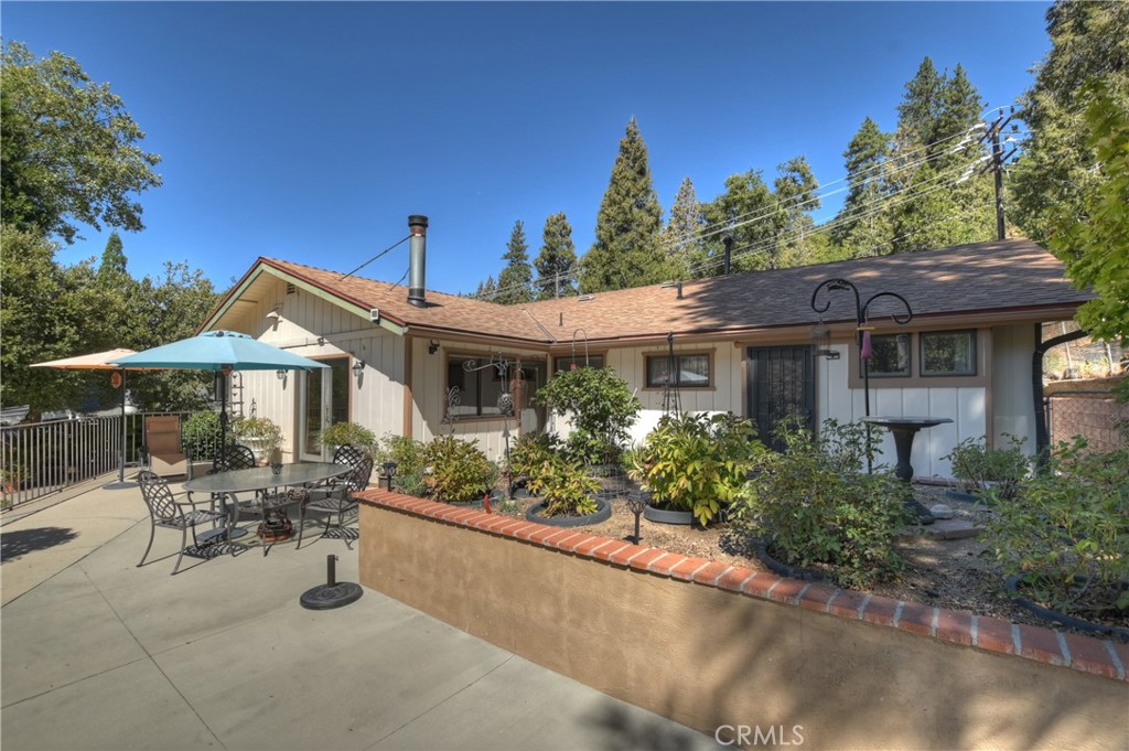 23167 Brookside Road Crestline, CA 92325 - Photo 2 of 49 a front view of a house with a garden and sitting area