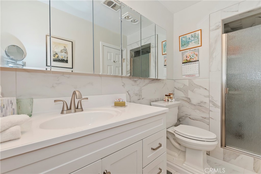 23167 Brookside Road Crestline, CA 92325 - Photo 30 of 49 a bathroom with a toilet a sink and mirror