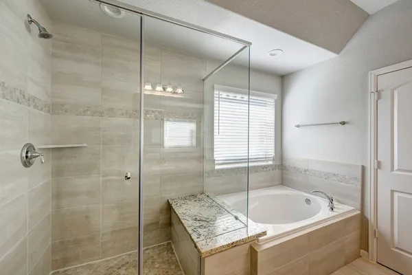 a spacious bedroom with a bed a chandelier and dresser