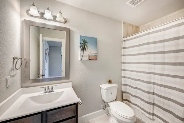 a bathroom with a sink a toilet a shower and a mirror