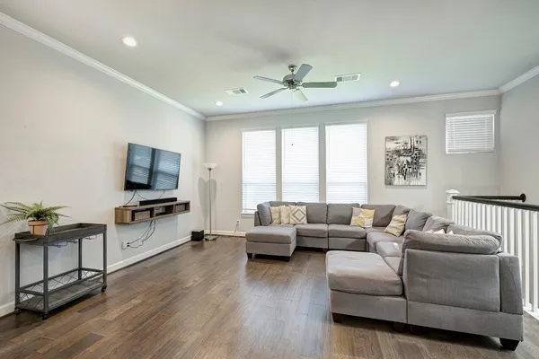 a living room with furniture flat screen tv and a large window