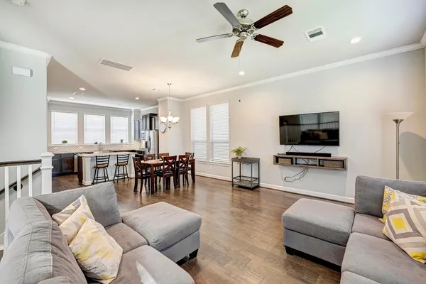 a living room with furniture and a flat screen tv with kitchen view