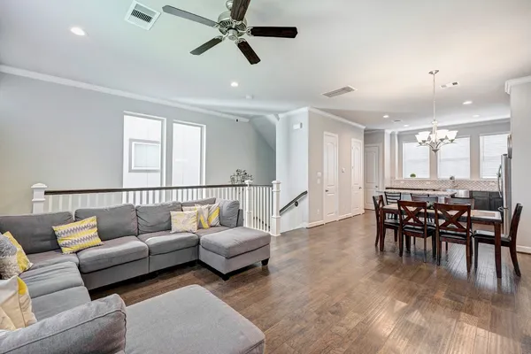 a living room with furniture and a dining table with wooden floor