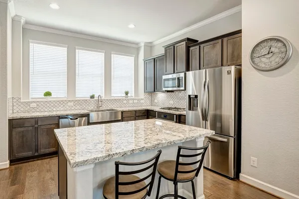 a kitchen with stainless steel appliances granite countertop a sink stove and refrigerator