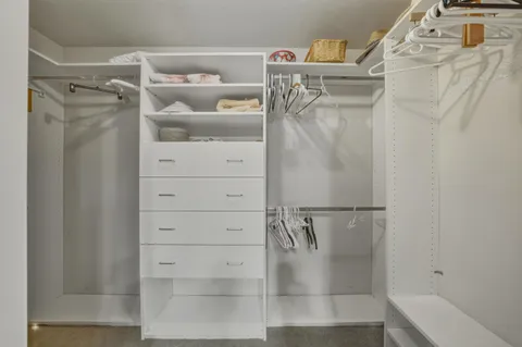 a view of walk in closet with clothes and shoes