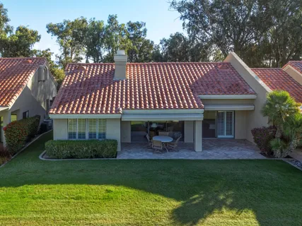 a front view of a house with a garden and patio