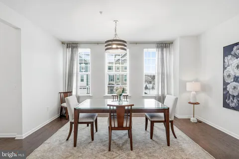 a view of a a dining room with furniture window and wooden floor