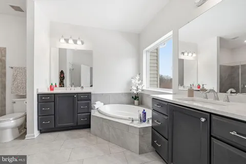 a bathroom with a sink vanity tub and shower
