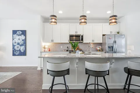 a kitchen with stainless steel appliances a sink a stove a refrigerator and cabinets