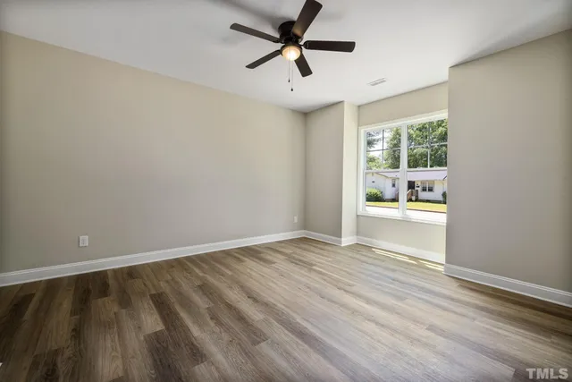 a view of a room with wooden floor and a ceiling fan