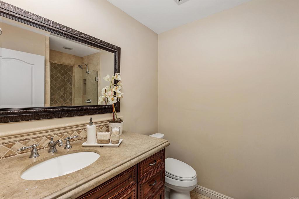 16346 Via Del Alba Rancho Santa Fe, CA 92067 - Photo 21 of 34 a bathroom with a granite countertop sink a toilet and mirror