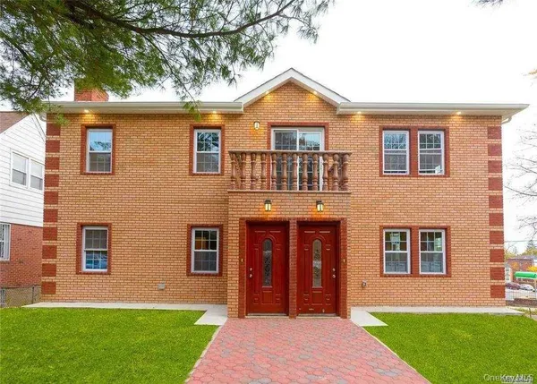 front view of a brick house with a yard