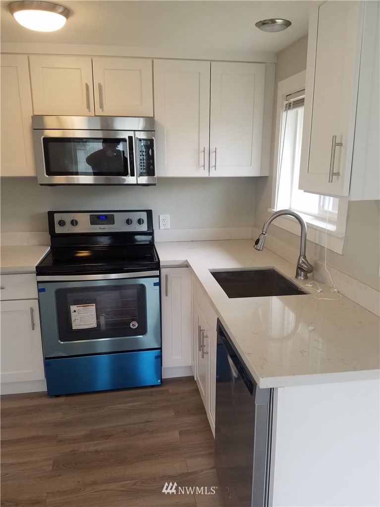 58 Shattuck Avenue South Renton, WA 98057 - Photo 5 of 13 a kitchen with stainless steel appliances a stove a microwave a sink and cabinets