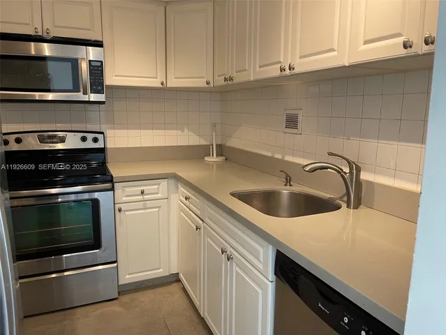 a kitchen with a sink and stove top oven