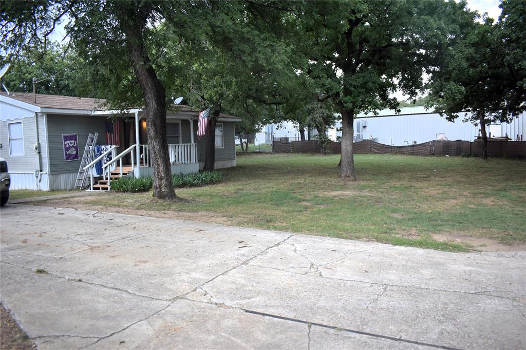 4550 Dick Price Road Fort Worth, TX 76140 - Photo 15 of 21 a view of a barn house with a big yard and large trees