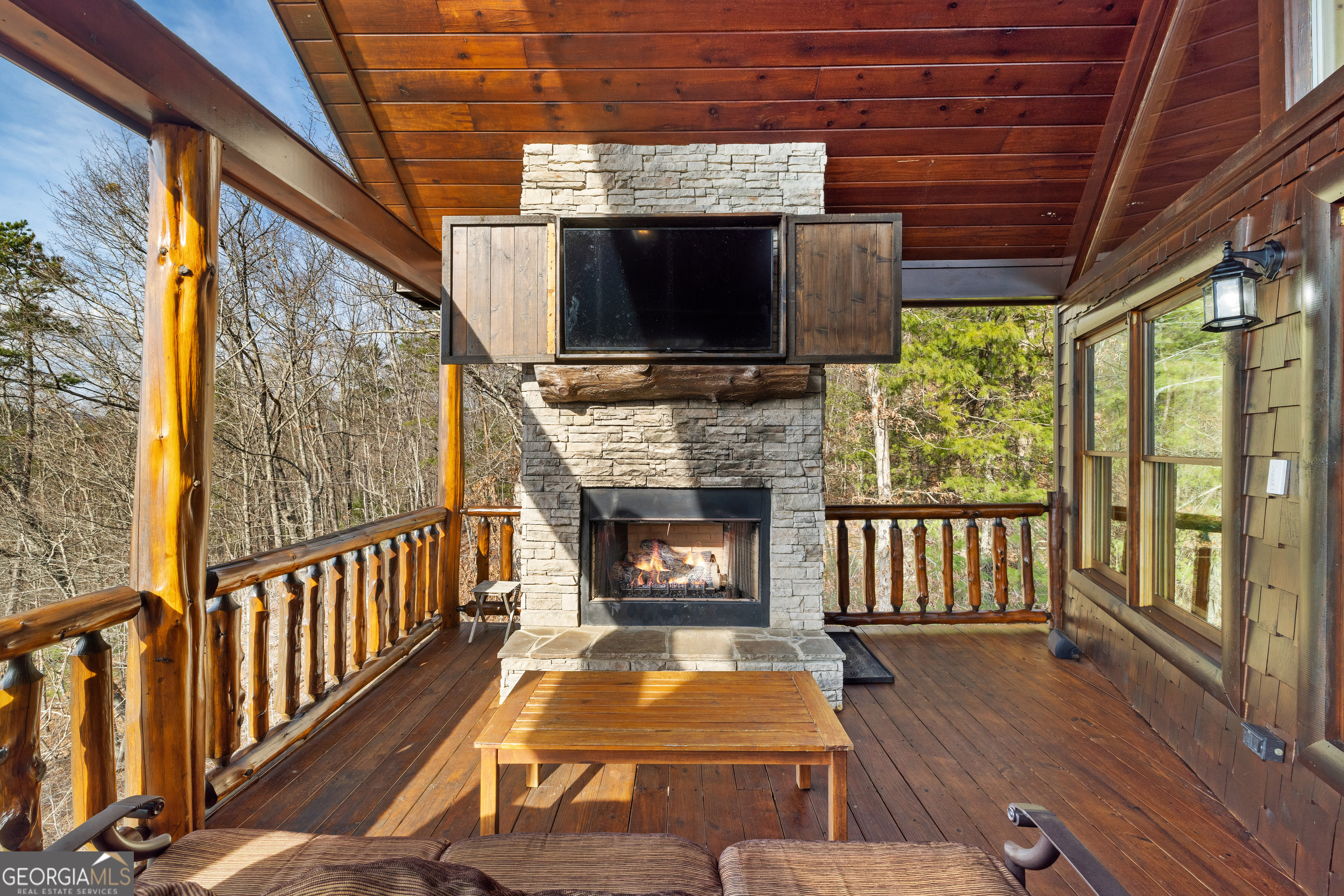 180 Cinnamon Bear Road Mineral Bluff, GA 30559 - Photo 13 of 49 a living room with a fireplace a flat screen tv and a floor to ceiling window