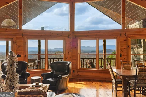 a living room with furniture and floor to ceiling windows