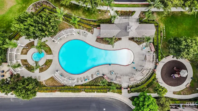an aerial view of a swimming pool with a yard and plants