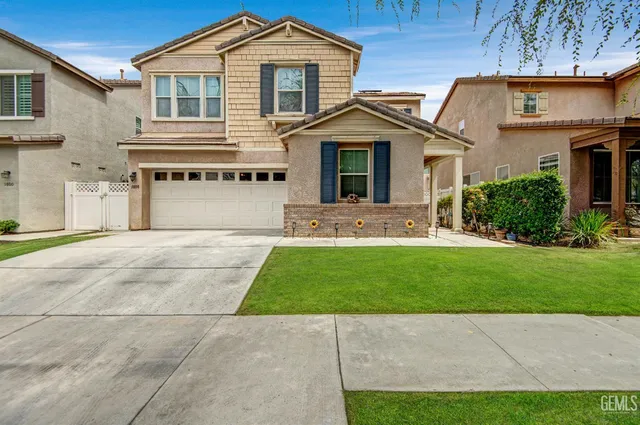 a front view of a house with a garden and yard