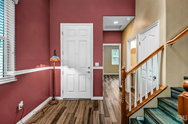 a view of front door with wooden floor and stairs