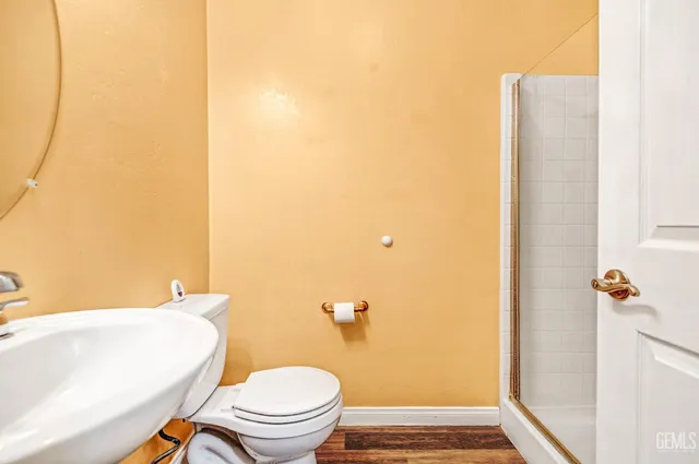 a white toilet sitting next to a bathroom sink and a mirror
