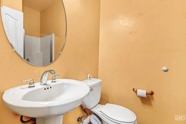 a bathroom with a sink a toilet and mirror