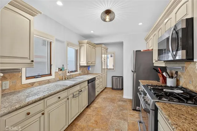 a kitchen with stainless steel appliances granite countertop a stove and a refrigerator