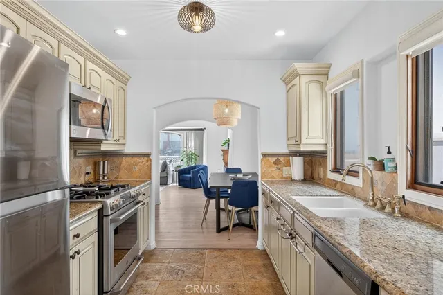 a large kitchen with a large window and stainless steel appliances