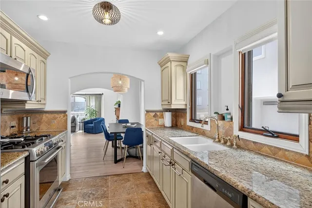 a kitchen with stainless steel appliances granite countertop a stove a microwave and a dining table