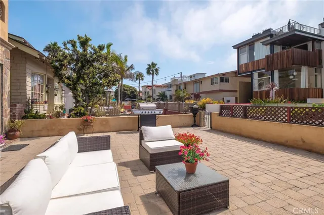 a view of a patio with couches and table and chairs and potted plants