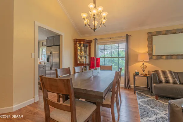 a view of a dining room with furniture wooden floor and chandelier