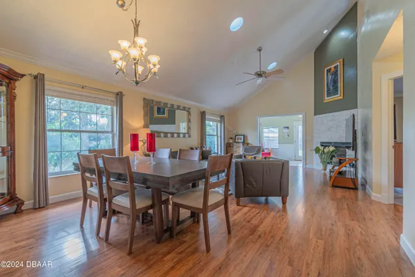 a view of a dining room with furniture a chandelier and wooden floor