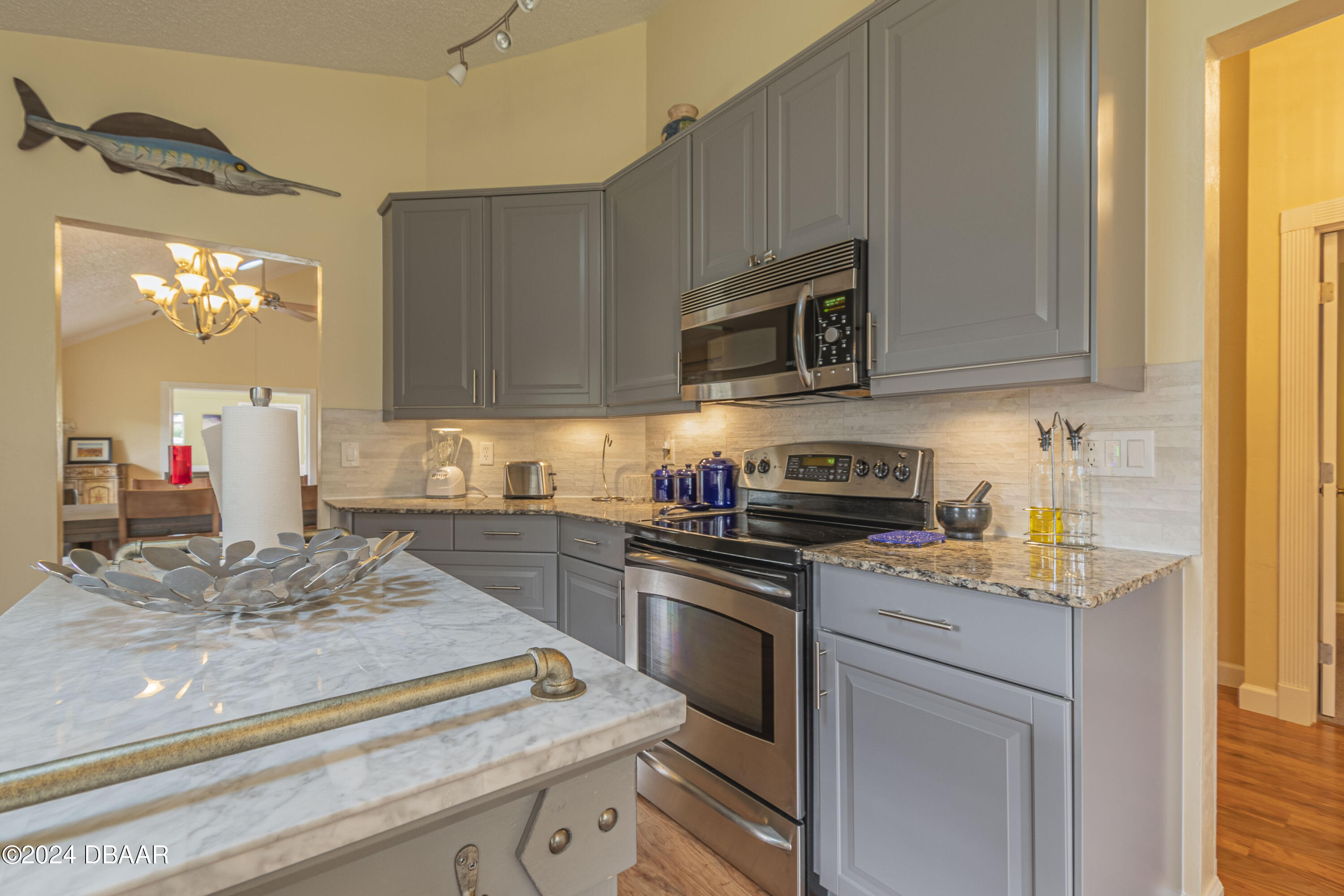6236 Clover Bend Drive Port Orange, FL 32127 - Photo 14 of 73 a kitchen with kitchen island granite countertop a sink cabinets and stainless steel appliances
