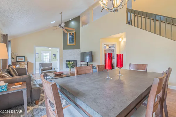 a view of a dining room with furniture a chandelier and wooden floor