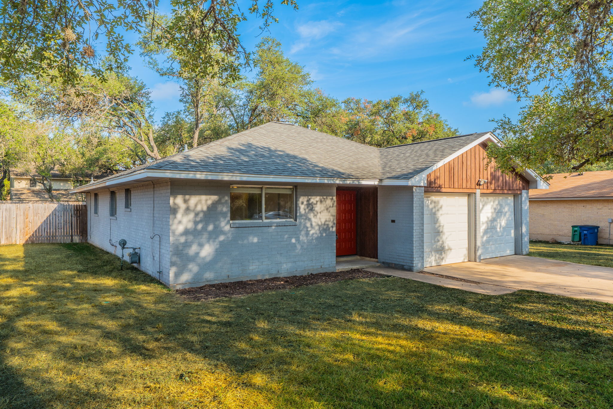 5628 Wagon Train Road Austin, TX 78749 - Photo 22 of 26 Mature trees shade a classic single-story brick exterior featuring a two-car garage.