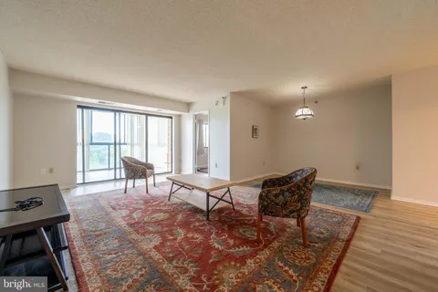 a living room with furniture and a floor to ceiling window