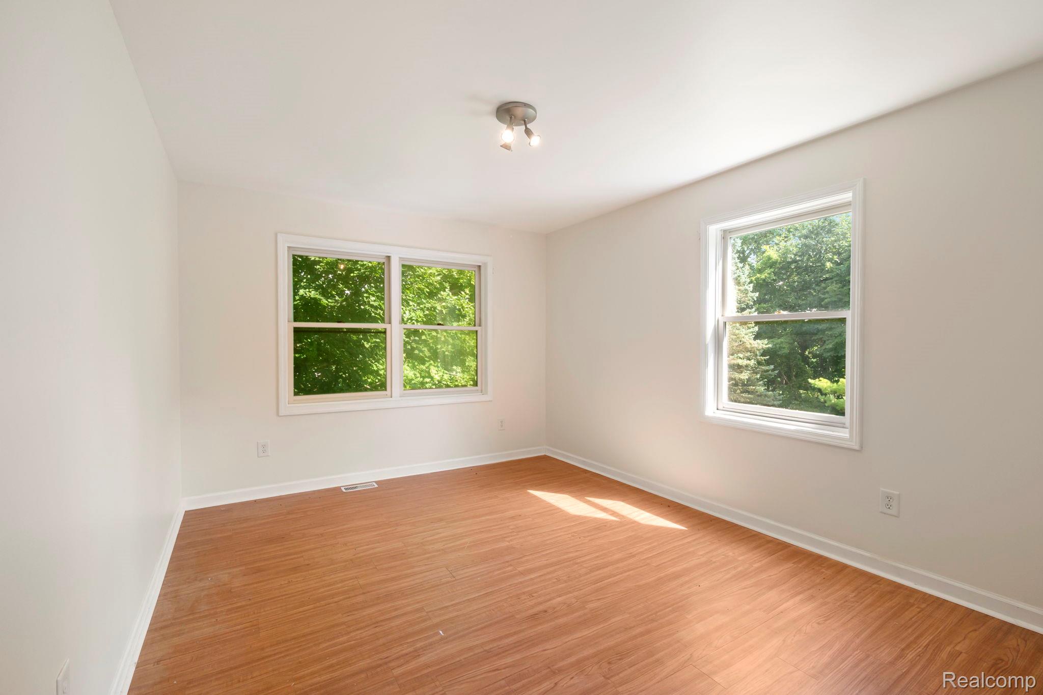 76565 McFadden Road Armada, MI 48005 - Photo 37 of 95 Wood-finish flooring with white trim, white walls, and a track lighting fixture