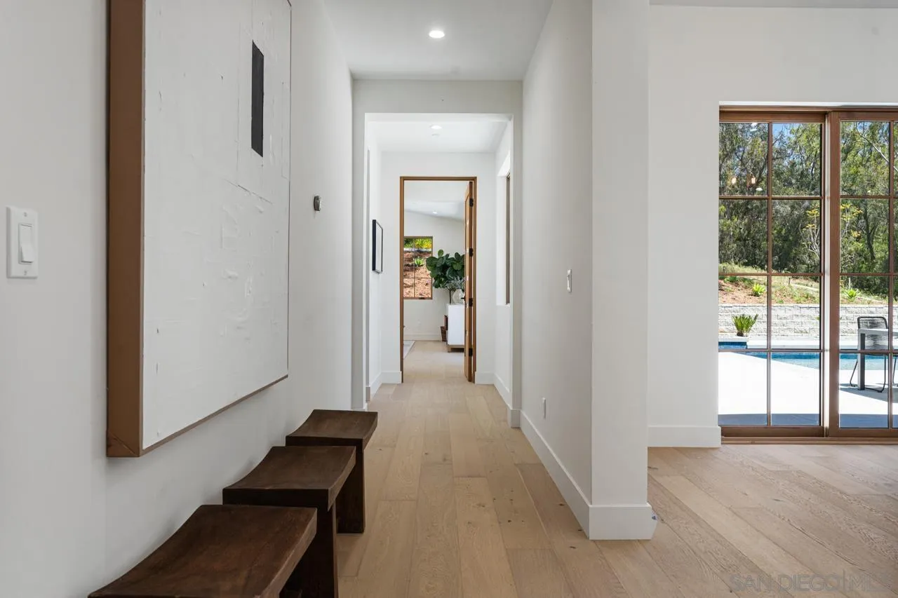 15245 El Camino Real Rancho Santa Fe, CA 92067 - Photo 21 of 41 a view of hallway with a large window and wooden floor
